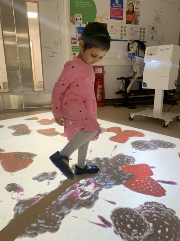 child playing with the new interactive projection systems introduced at the hospital